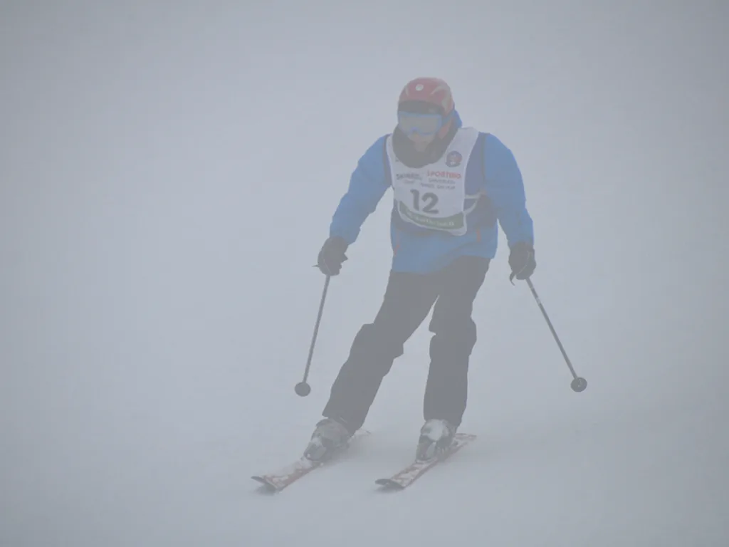 Skifahrer mit Startnummer 12 in roter Mütze.